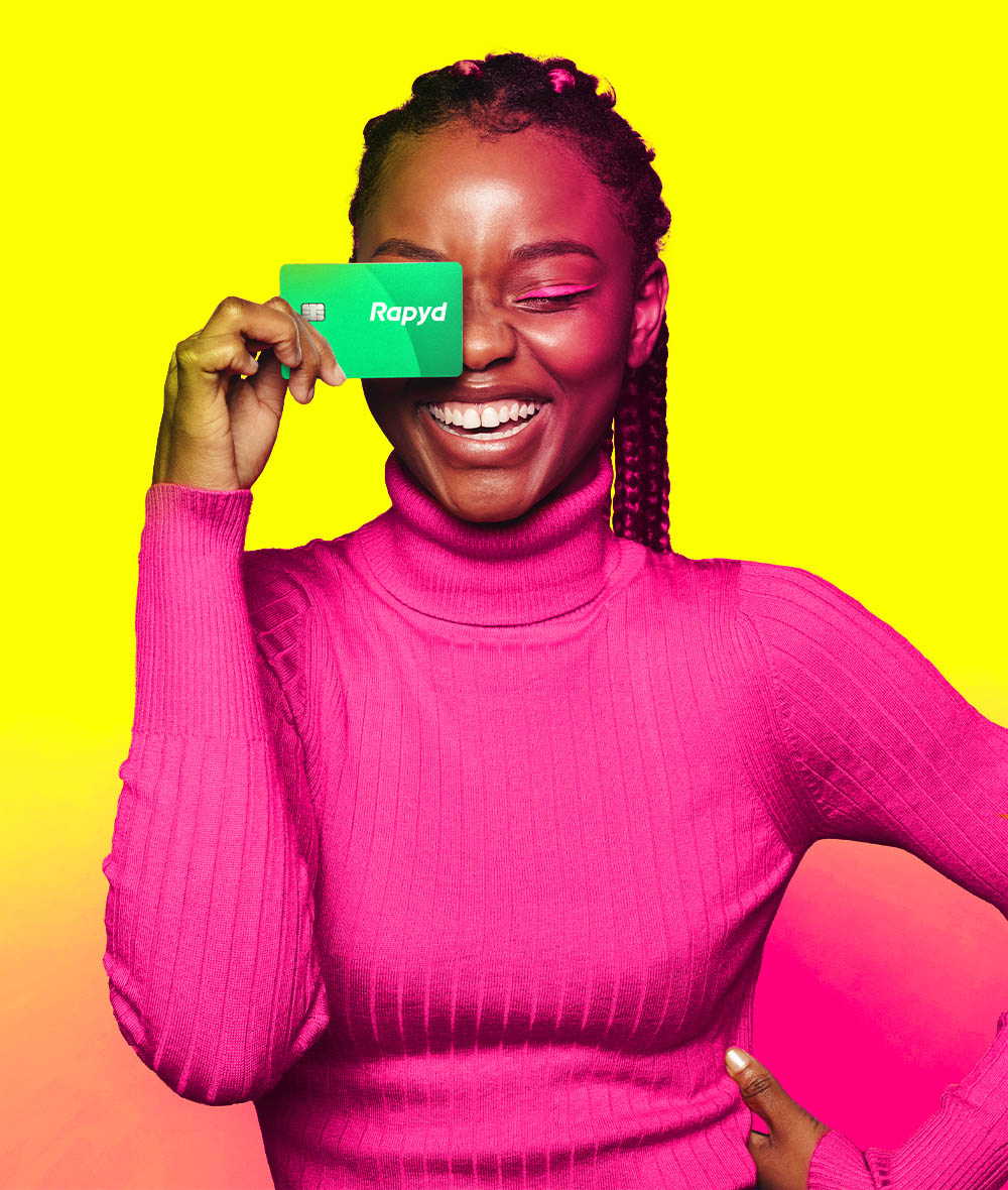 A woman smiles, placing a credit card over one of her eyes.