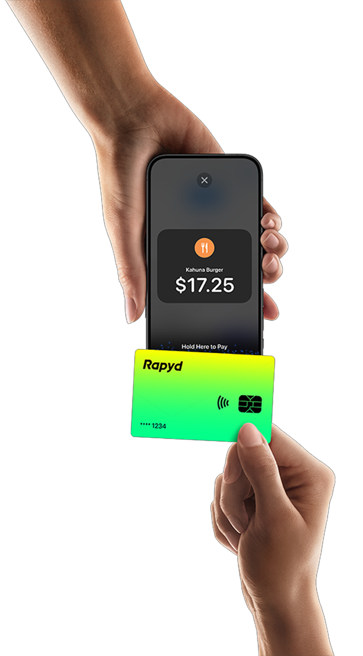 A hand holds a Rapyd credit card and uses tap to pay technology.