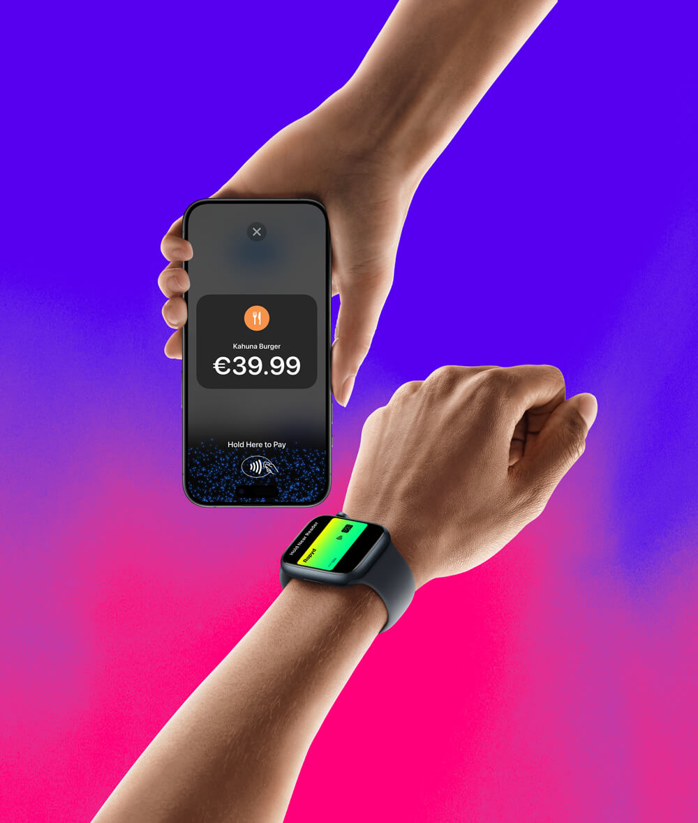 A hand wearing an Apple Watch with a Rapyd credit card about to pay on an iPhone that has a hold here to pay screen on it.