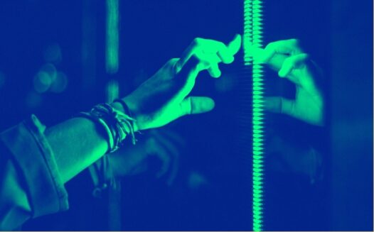 A finger touches a window showing a reflection