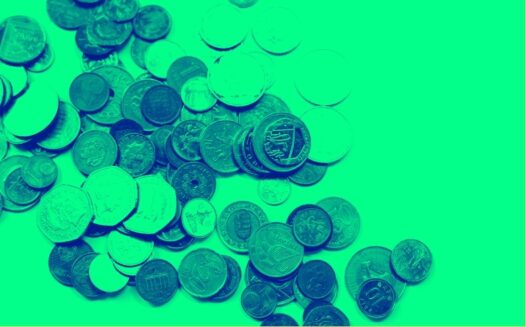 Coins from different countries scattered on a blank surface