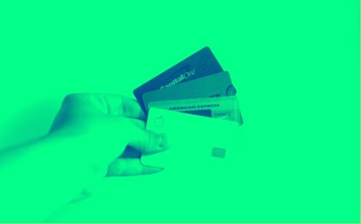 A person holding up several credit cards in their hand