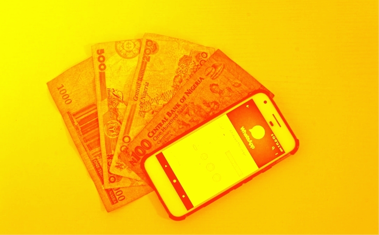 A phone with digital wallet open atop bills from different countries